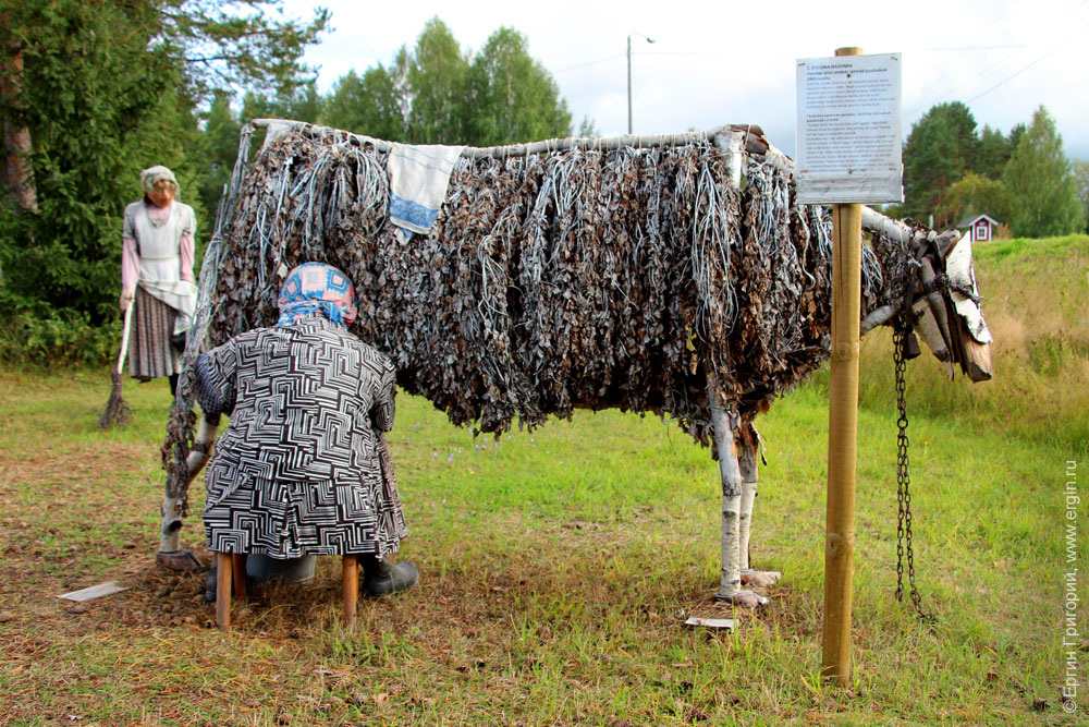 Женщина доит деревянную корову из венников