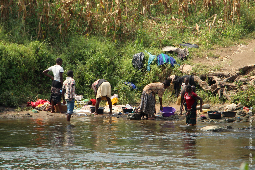 Семья стирает белье в Ниле Уганда