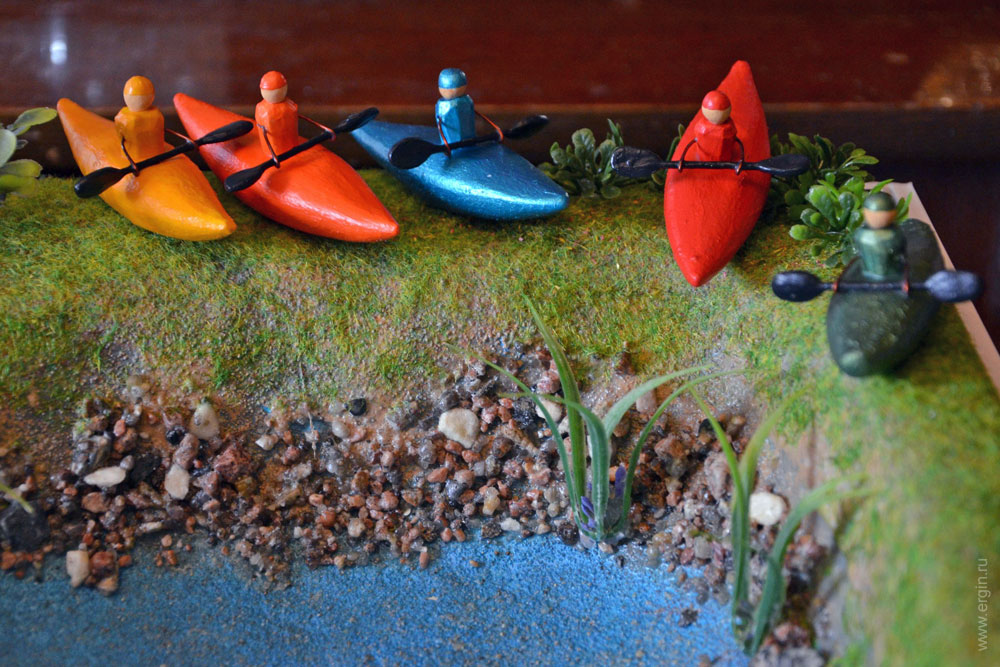Модели каякеров слаломистов возле русла макета слаломного канала 
