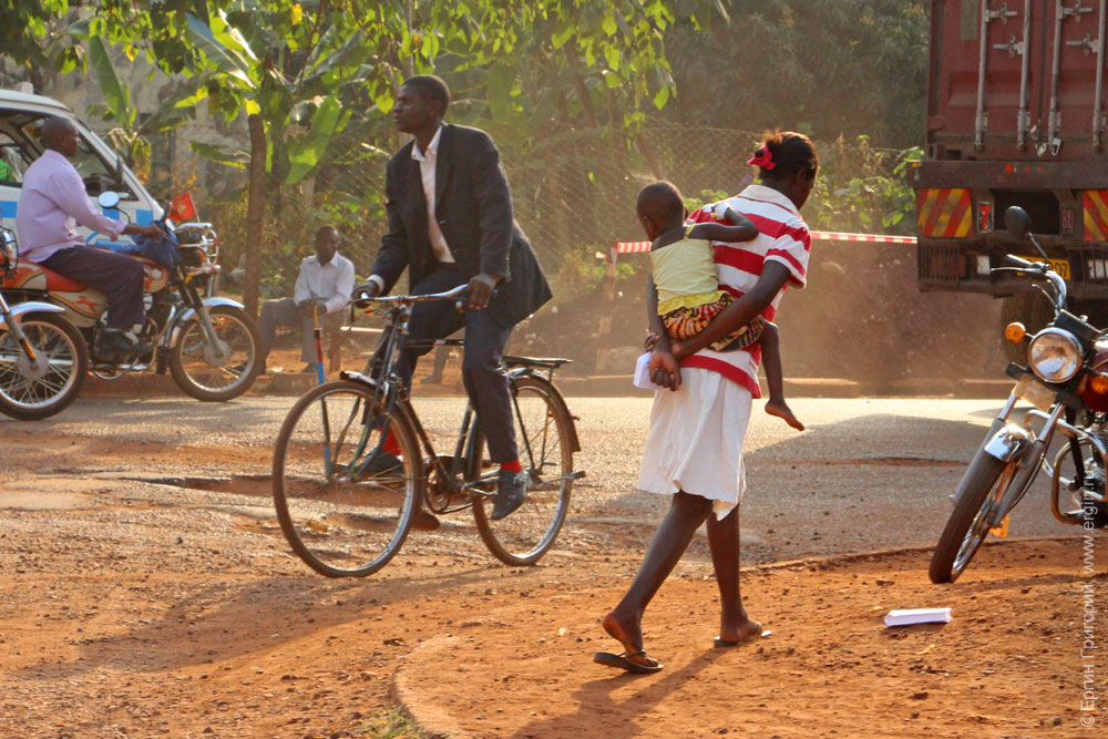 Мама переносит ребенка на спине Уганда