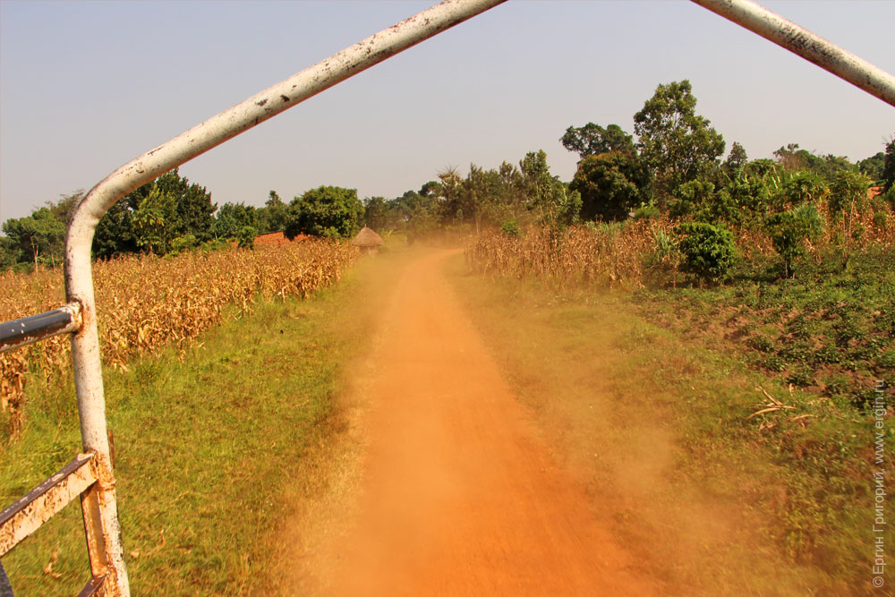 Красное пылевое облако на дороге в Уганде