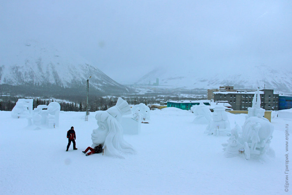 Снежные статуи на улице в Снежной деревне на фоне гор Кировск Хибины