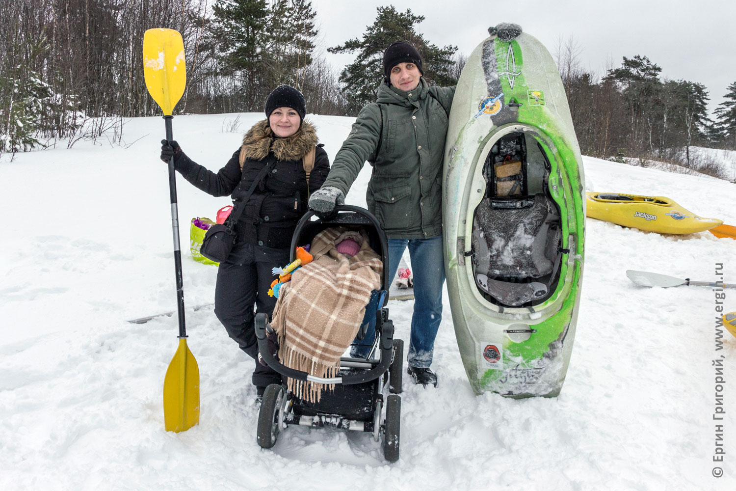 Сноукаякерская семья зимой с каяком веслом и коляской