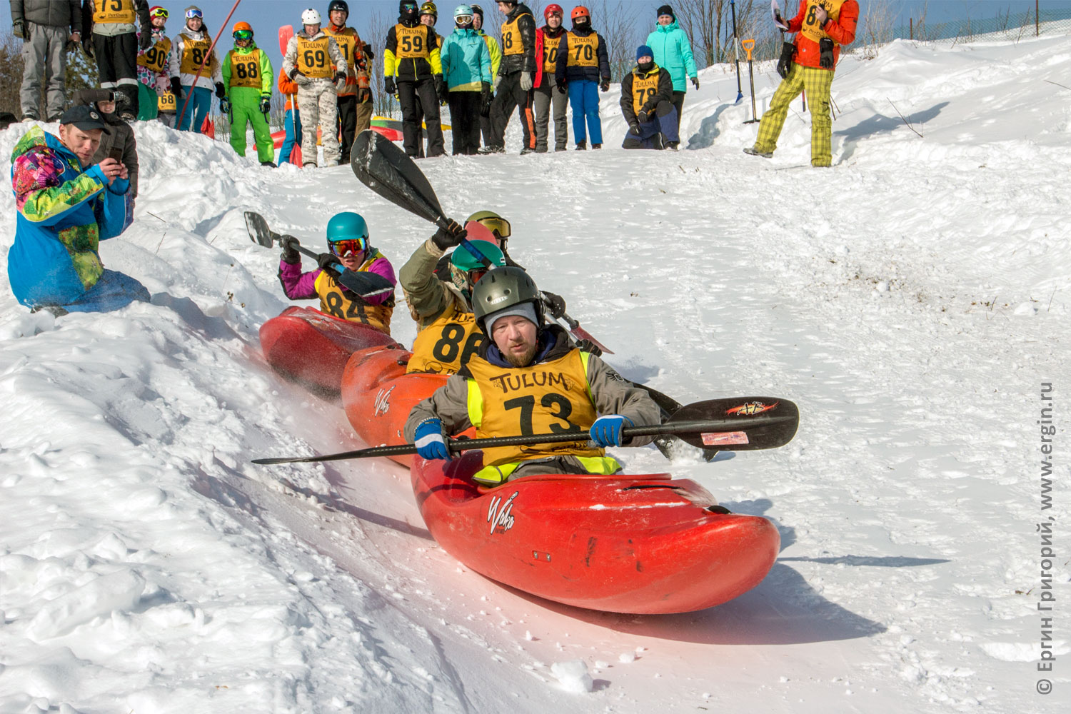 Со снежной  горы съезжает в каяке организатор соревнований по сноукаякингу