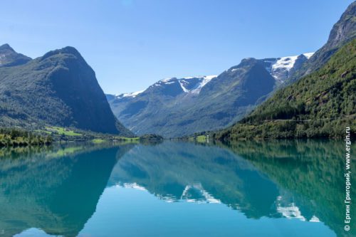 Горы и снежники отражаются в озере Норвегия