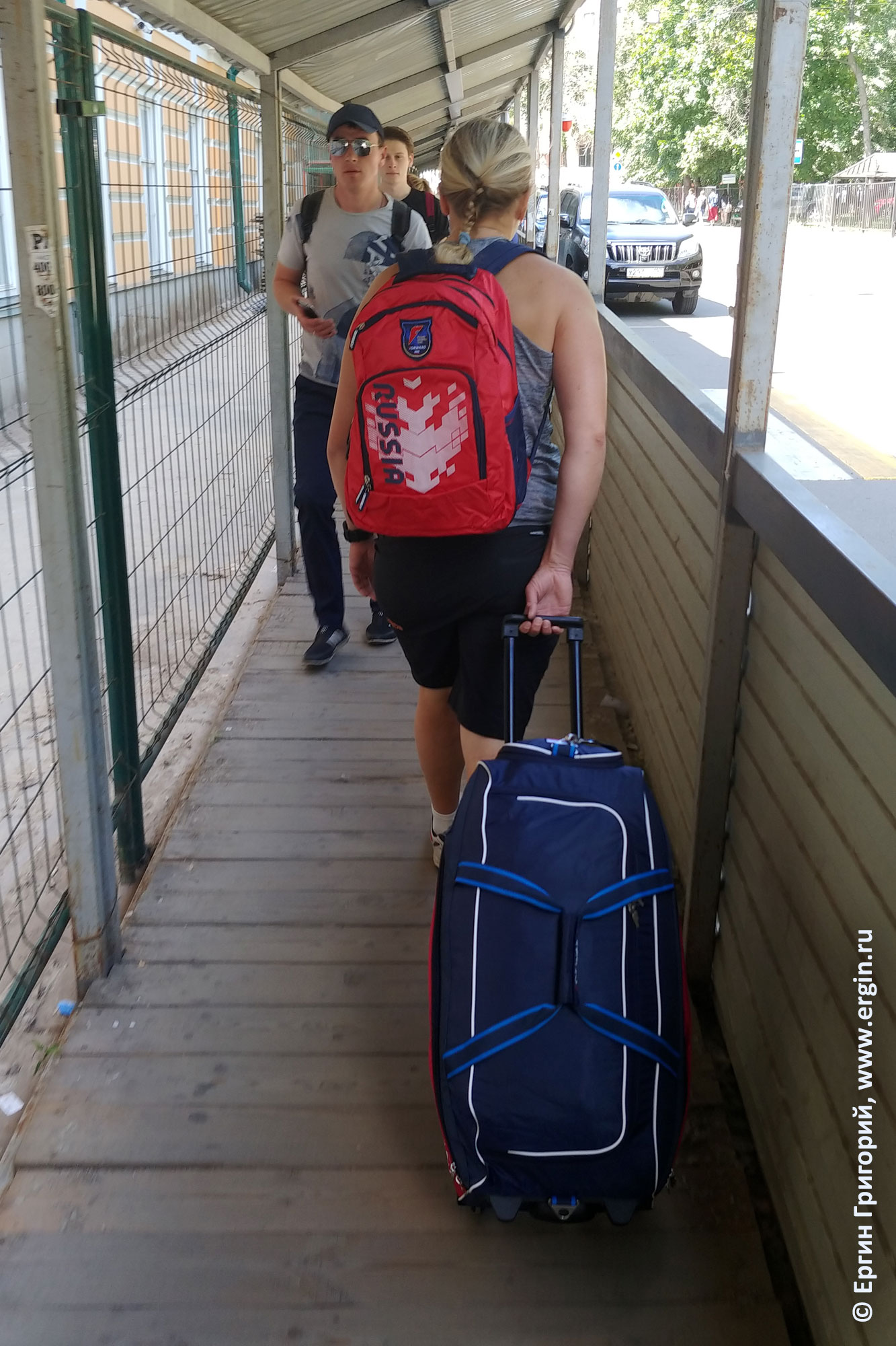 Спортсмен сборной России несет форму в сумке и рюкзаке